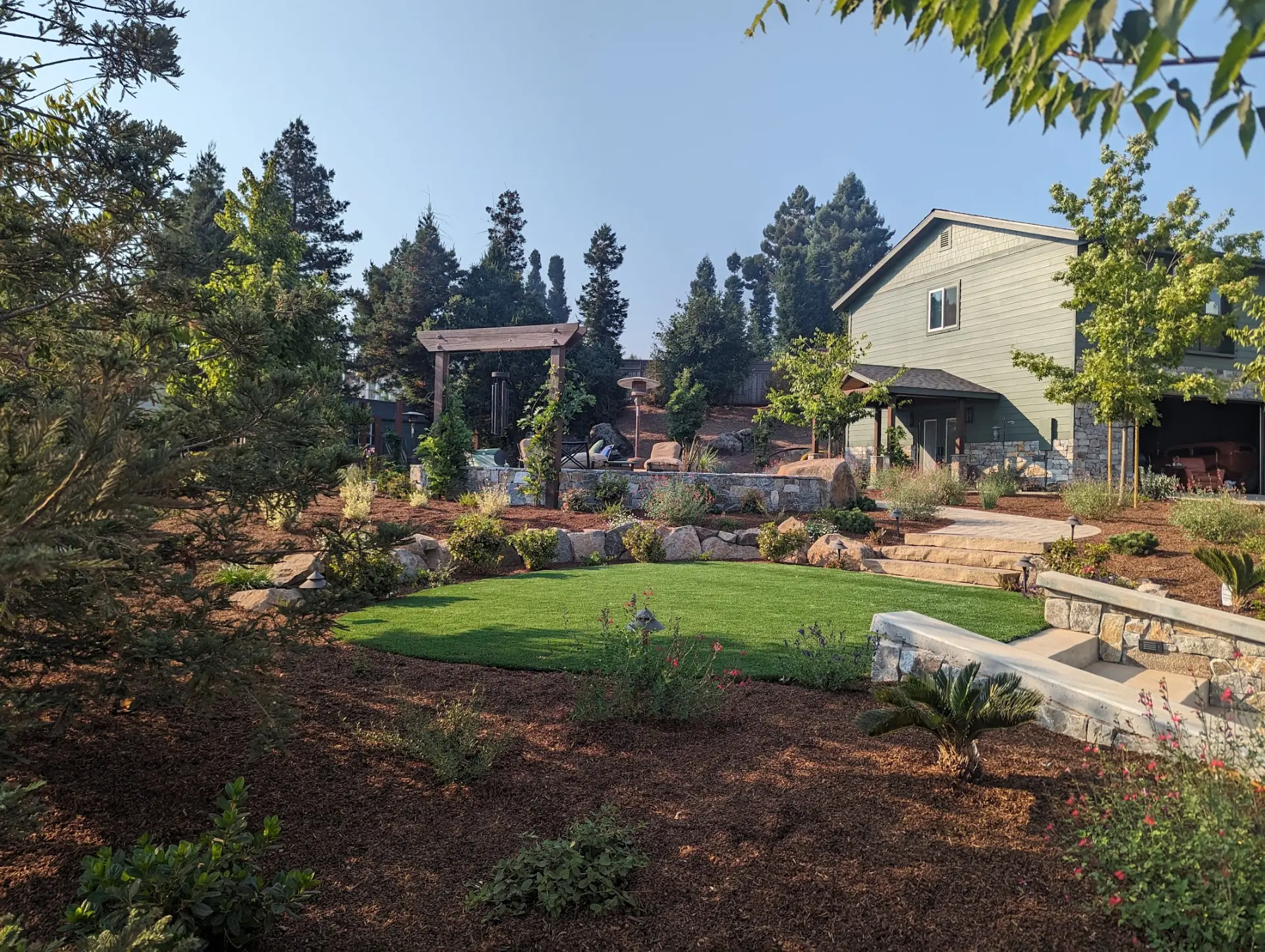 North Bay backyard with arbor, stone retaining walls, paver steps and lawn built by QBR
