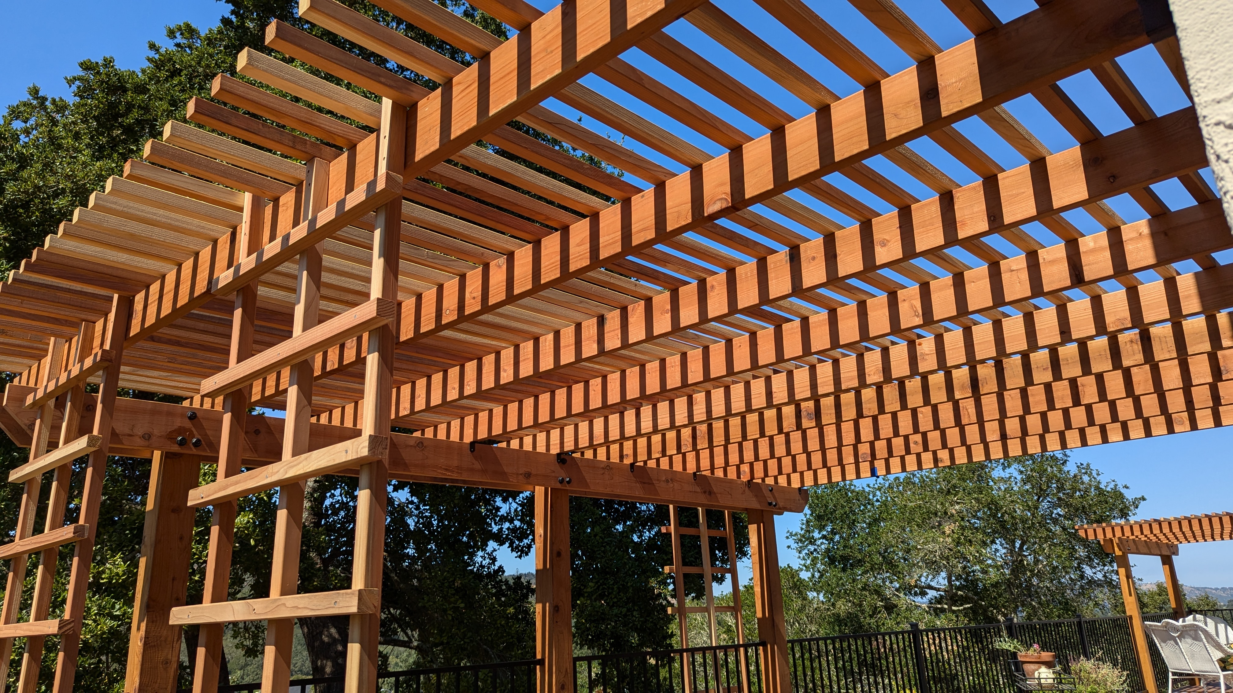 Custom redwood pergola over a hillside patio